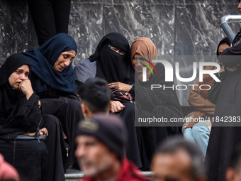 Palestinian women mourn relatives killed in an Israeli strike during their funeral at the al-Awda Hospital at the Nuseirat refugee Camp in t...