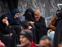 Palestinian women mourn relatives killed in an Israeli strike during their funeral at the al-Awda Hospital at the Nuseirat refugee Camp in t...