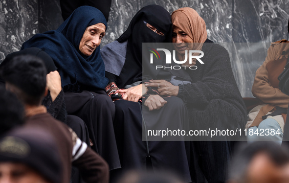 Palestinian women mourn relatives killed in an Israeli strike during their funeral at the al-Awda Hospital at the Nuseirat refugee Camp in t...