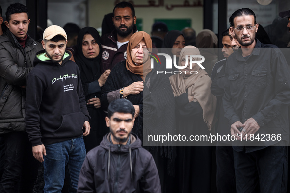 Palestinian women mourn relatives killed in an Israeli strike during their funeral at the al-Awda Hospital at the Nuseirat refugee Camp in t...