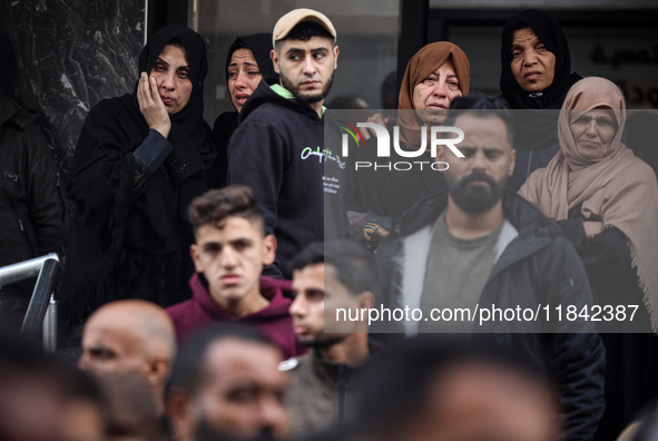 Palestinian women mourn relatives killed in an Israeli strike during their funeral at the al-Awda Hospital at the Nuseirat refugee Camp in t...