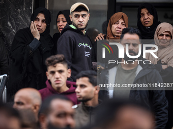 Palestinian women mourn relatives killed in an Israeli strike during their funeral at the al-Awda Hospital at the Nuseirat refugee Camp in t...