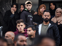 Palestinian women mourn relatives killed in an Israeli strike during their funeral at the al-Awda Hospital at the Nuseirat refugee Camp in t...