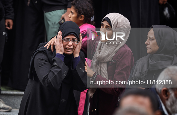 Palestinian women mourn relatives killed in an Israeli strike during their funeral at the al-Awda Hospital at the Nuseirat refugee Camp in t...