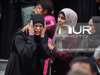 Palestinian women mourn relatives killed in an Israeli strike during their funeral at the al-Awda Hospital at the Nuseirat refugee Camp in t...