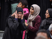 Palestinian women mourn relatives killed in an Israeli strike during their funeral at the al-Awda Hospital at the Nuseirat refugee Camp in t...