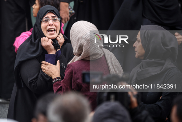 Palestinian women mourn relatives killed in an Israeli strike during their funeral at the al-Awda Hospital at the Nuseirat refugee Camp in t...