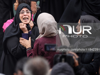 Palestinian women mourn relatives killed in an Israeli strike during their funeral at the al-Awda Hospital at the Nuseirat refugee Camp in t...