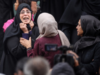 Palestinian women mourn relatives killed in an Israeli strike during their funeral at the al-Awda Hospital at the Nuseirat refugee Camp in t...