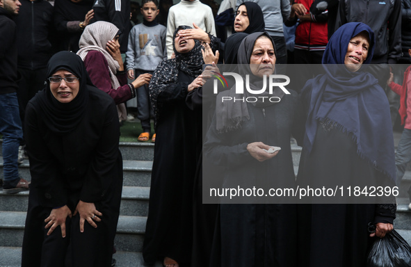 Palestinian women mourn relatives killed in an Israeli strike during their funeral at the al-Awda Hospital at the Nuseirat refugee Camp in t...