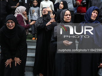 Palestinian women mourn relatives killed in an Israeli strike during their funeral at the al-Awda Hospital at the Nuseirat refugee Camp in t...