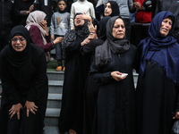 Palestinian women mourn relatives killed in an Israeli strike during their funeral at the al-Awda Hospital at the Nuseirat refugee Camp in t...