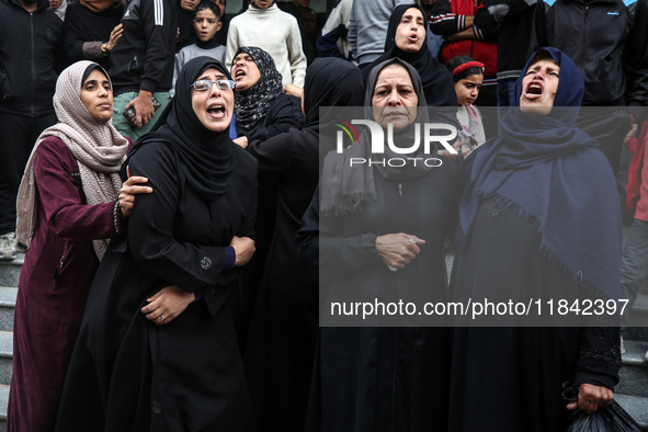 Palestinian women mourn relatives killed in an Israeli strike during their funeral at the al-Awda Hospital at the Nuseirat refugee Camp in t...