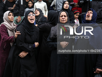 Palestinian women mourn relatives killed in an Israeli strike during their funeral at the al-Awda Hospital at the Nuseirat refugee Camp in t...