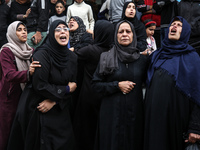 Palestinian women mourn relatives killed in an Israeli strike during their funeral at the al-Awda Hospital at the Nuseirat refugee Camp in t...