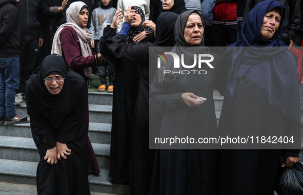 Palestinian women mourn relatives killed in an Israeli strike during their funeral at the al-Awda Hospital at the Nuseirat refugee Camp in t...