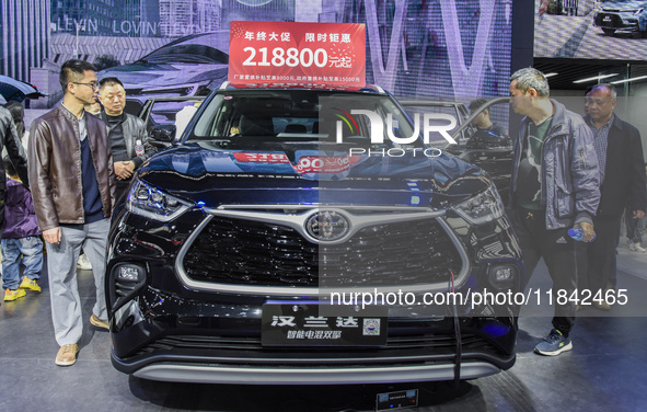 Visitors view Highlander electric hybrid cars at the 2024 ASEAN International Auto Show in Nanning, China, on December 7, 2024. 