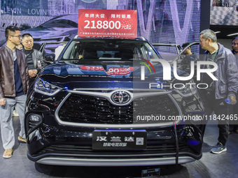 Visitors view Highlander electric hybrid cars at the 2024 ASEAN International Auto Show in Nanning, China, on December 7, 2024. (