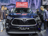 Visitors view Highlander electric hybrid cars at the 2024 ASEAN International Auto Show in Nanning, China, on December 7, 2024. (