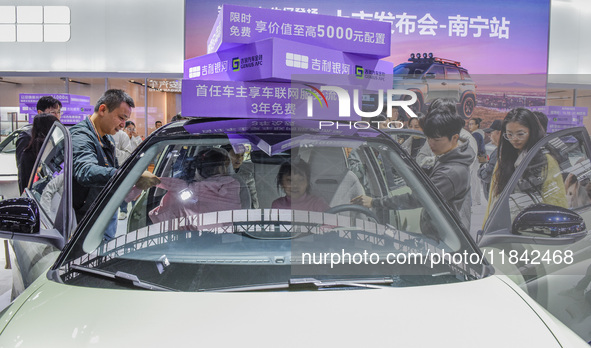 Visitors view Geely cars at the 2024 ASEAN International Auto Show in Nanning, China, on December 7, 2024. 