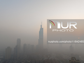 Buildings loom under heavy fog in Nanjing, Jiangsu province, China, on December 7, 2024. (