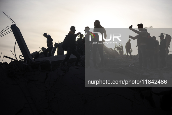 Palestinians inspect the damage after an Israeli strike on the Nuseirat refugee camp in the central Gaza Strip on December 7, 2024, amid the...