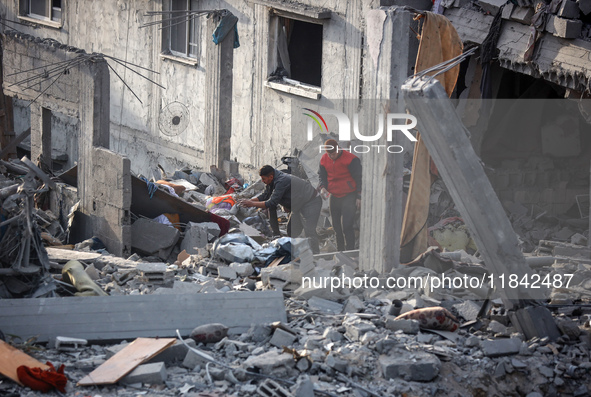 Palestinians inspect the damage after an Israeli strike on the Nuseirat refugee camp in the central Gaza Strip on December 7, 2024, amid the...