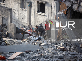 Palestinians inspect the damage after an Israeli strike on the Nuseirat refugee camp in the central Gaza Strip on December 7, 2024, amid the...