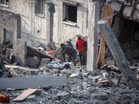 Palestinians inspect the damage after an Israeli strike on the Nuseirat refugee camp in the central Gaza Strip on December 7, 2024, amid the...