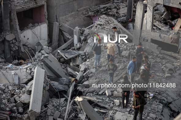 Palestinians inspect the damage after an Israeli strike on the Nuseirat refugee camp in the central Gaza Strip on December 7, 2024, amid the...