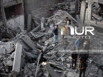 Palestinians inspect the damage after an Israeli strike on the Nuseirat refugee camp in the central Gaza Strip on December 7, 2024, amid the...