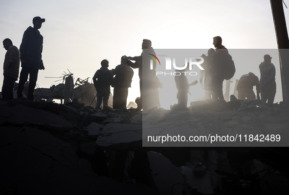 Palestinians inspect the damage after an Israeli strike on the Nuseirat refugee camp in the central Gaza Strip on December 7, 2024, amid the...