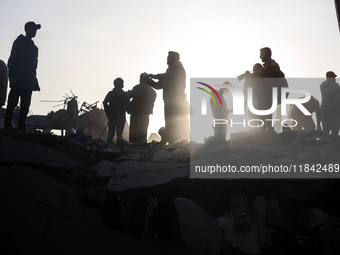 Palestinians inspect the damage after an Israeli strike on the Nuseirat refugee camp in the central Gaza Strip on December 7, 2024, amid the...