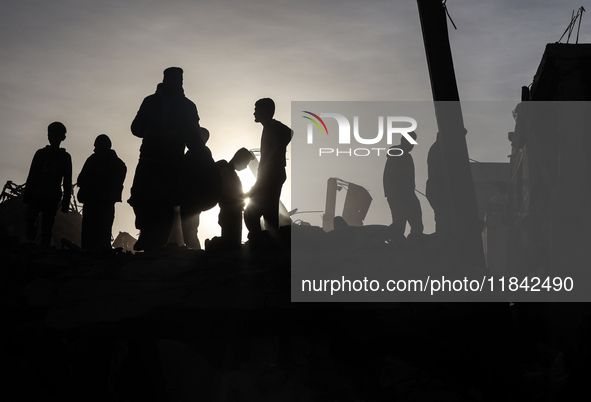 Palestinians inspect the damage after an Israeli strike on the Nuseirat refugee camp in the central Gaza Strip on December 7, 2024, amid the...