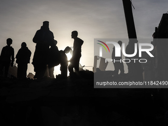 Palestinians inspect the damage after an Israeli strike on the Nuseirat refugee camp in the central Gaza Strip on December 7, 2024, amid the...