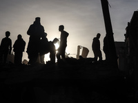 Palestinians inspect the damage after an Israeli strike on the Nuseirat refugee camp in the central Gaza Strip on December 7, 2024, amid the...