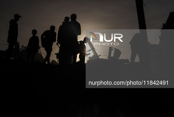 Palestinians inspect the damage after an Israeli strike on the Nuseirat refugee camp in the central Gaza Strip on December 7, 2024, amid the...