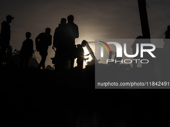 Palestinians inspect the damage after an Israeli strike on the Nuseirat refugee camp in the central Gaza Strip on December 7, 2024, amid the...