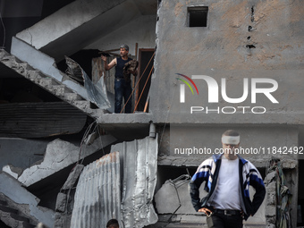 Palestinians inspect the damage after an Israeli strike on the Nuseirat refugee camp in the central Gaza Strip on December 7, 2024, amid the...