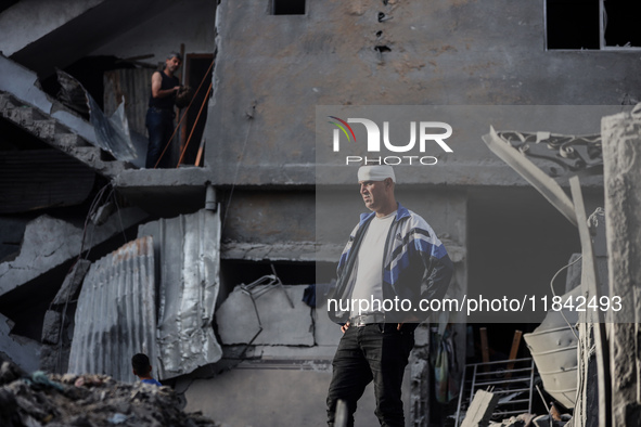 A Palestinian man stands atop the rubble of a building, destroyed in an Israeli strike, in the Nuseirat refugee Camp in the central Gaza Str...