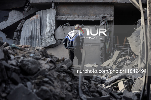 A Palestinian man stands atop the rubble of a building, destroyed in an Israeli strike, in the Nuseirat refugee Camp in the central Gaza Str...