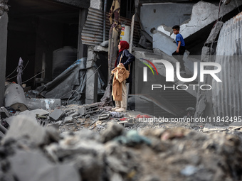 Palestinians inspect the damage after an Israeli strike on the Nuseirat refugee camp in the central Gaza Strip on December 7, 2024, amid the...