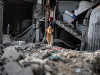 Palestinians inspect the damage after an Israeli strike on the Nuseirat refugee camp in the central Gaza Strip on December 7, 2024, amid the...