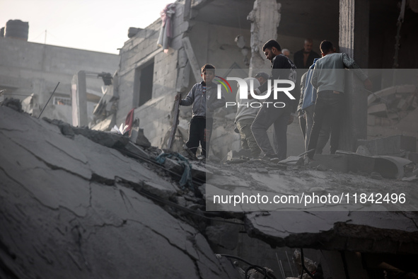 Palestinians inspect the damage after an Israeli strike on the Nuseirat refugee camp in the central Gaza Strip on December 7, 2024, amid the...