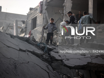 Palestinians inspect the damage after an Israeli strike on the Nuseirat refugee camp in the central Gaza Strip on December 7, 2024, amid the...