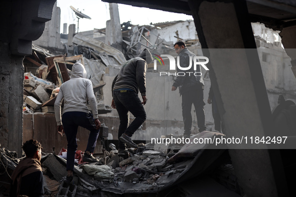 Palestinians inspect the damage after an Israeli strike on the Nuseirat refugee camp in the central Gaza Strip on December 7, 2024, amid the...