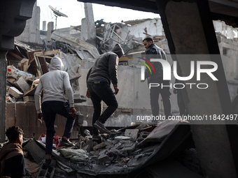 Palestinians inspect the damage after an Israeli strike on the Nuseirat refugee camp in the central Gaza Strip on December 7, 2024, amid the...