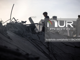 Palestinians inspect the damage after an Israeli strike on the Nuseirat refugee camp in the central Gaza Strip on December 7, 2024, amid the...