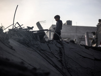 Palestinians inspect the damage after an Israeli strike on the Nuseirat refugee camp in the central Gaza Strip on December 7, 2024, amid the...