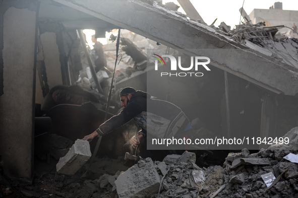 Palestinians inspect the damage after an Israeli strike on the Nuseirat refugee camp in the central Gaza Strip on December 7, 2024, amid the...